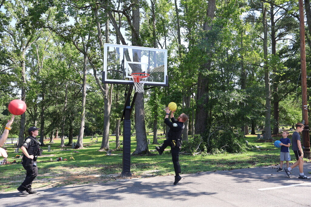 Police officers playing basketball with the children