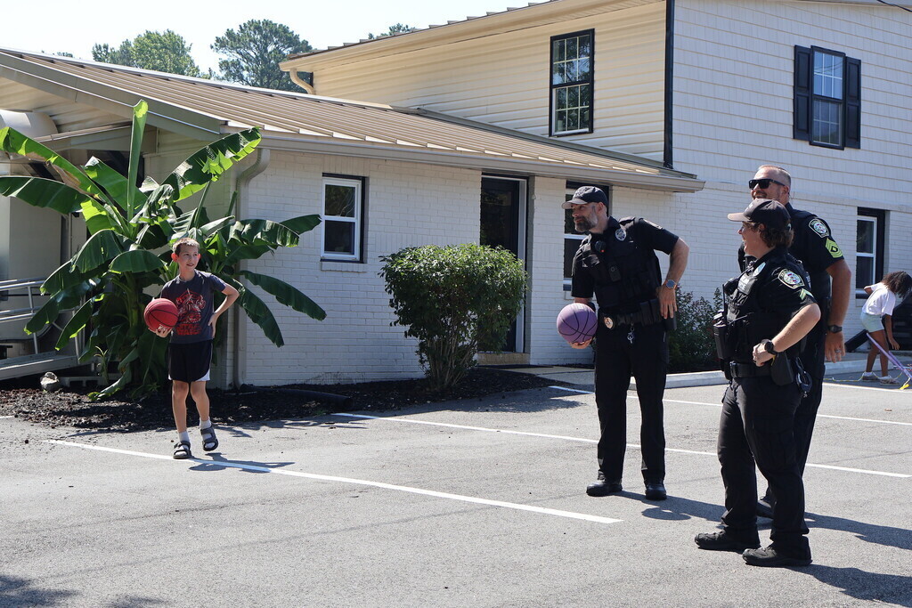 Police officers playing basketball with the children