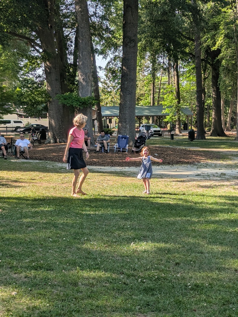Woman and child dancing to music in the park