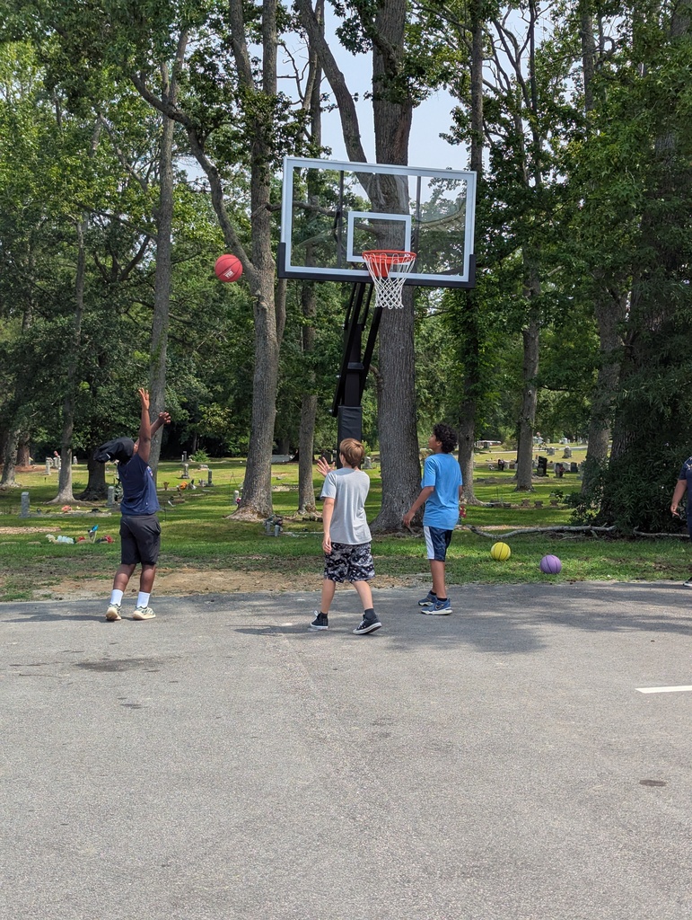 Three boys playing basketball outside