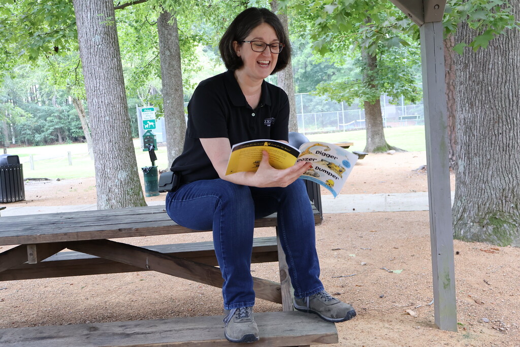 A woman reading a book at story time.