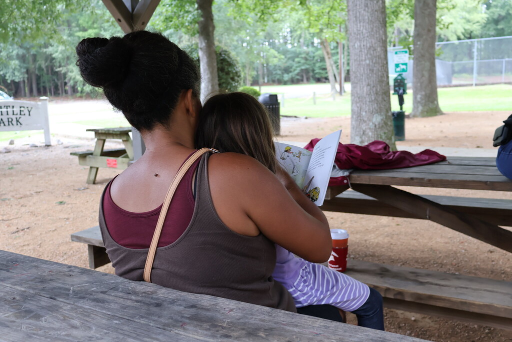 A woman and child reading along at story time.