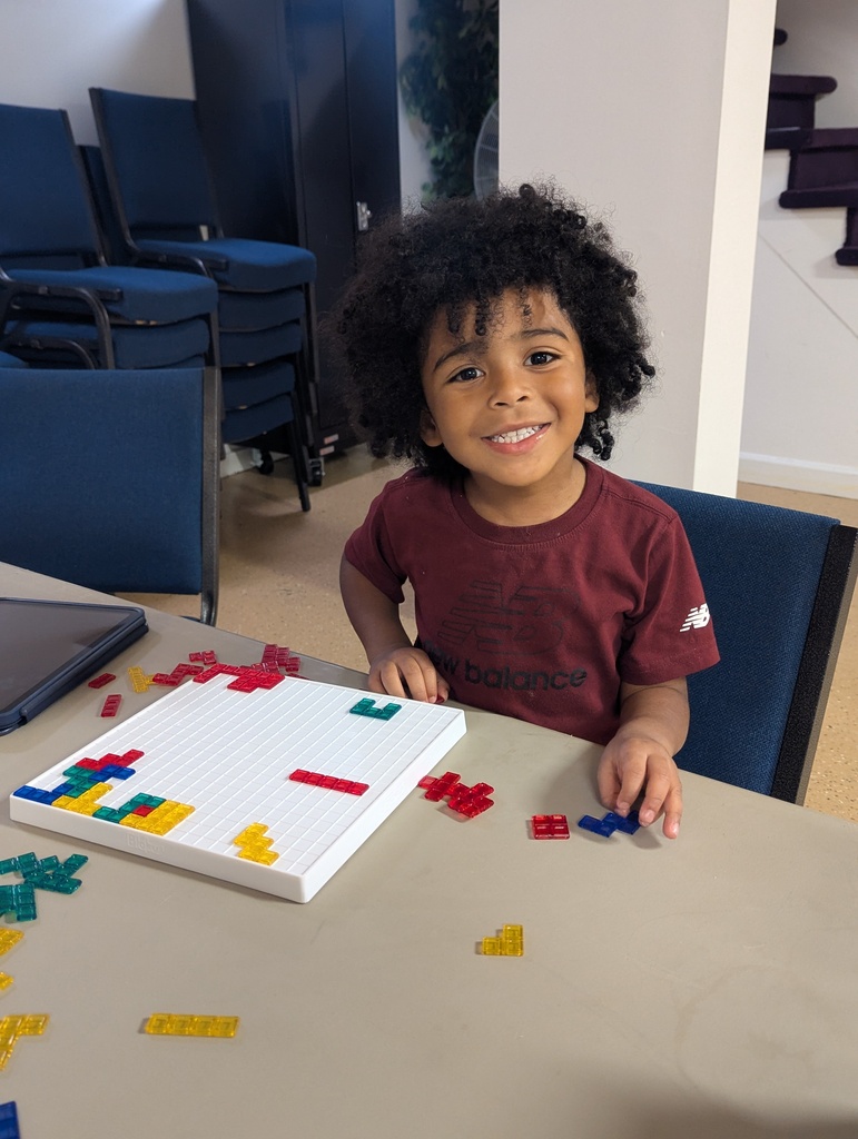 Little boy playing Blockus.
