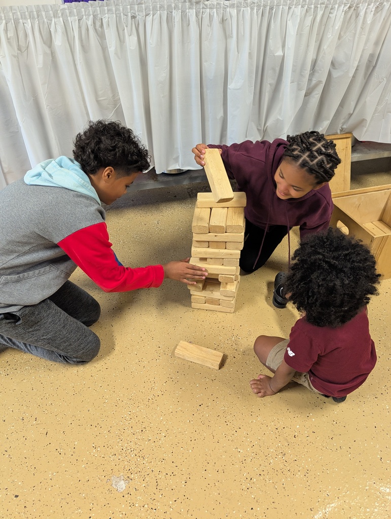 Three children playing Jenga.