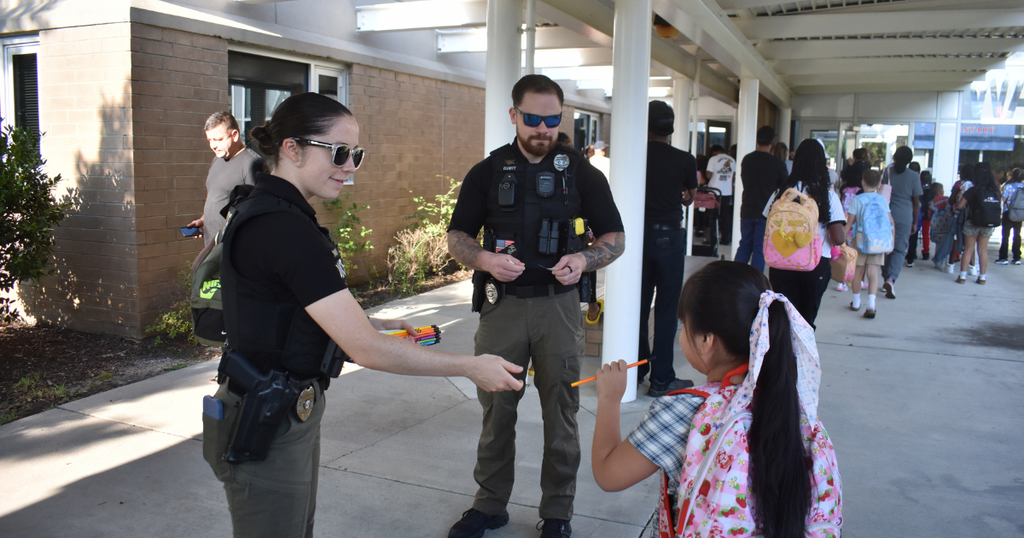 female cop and male cop and a child and pencils