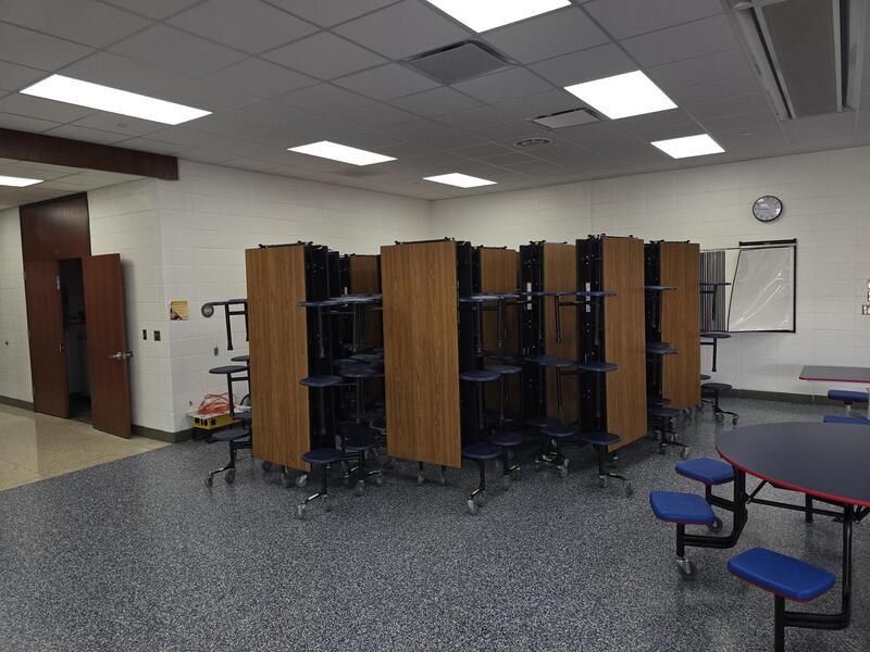 Several fold up lunch tables in a corner