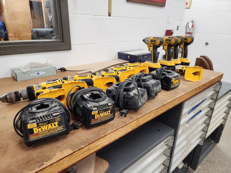 Multiple DeWalt tools laying on a shop table