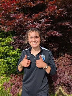 smiling student giving two thumbs up