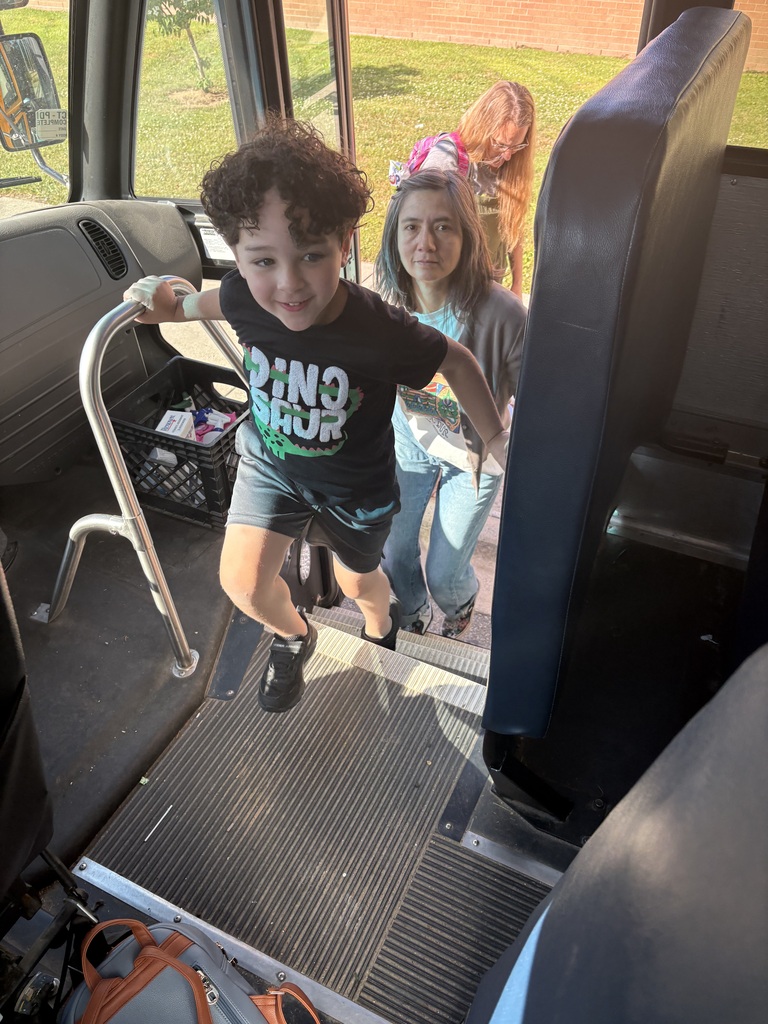 Boy smiling as he climbs the bus stairs