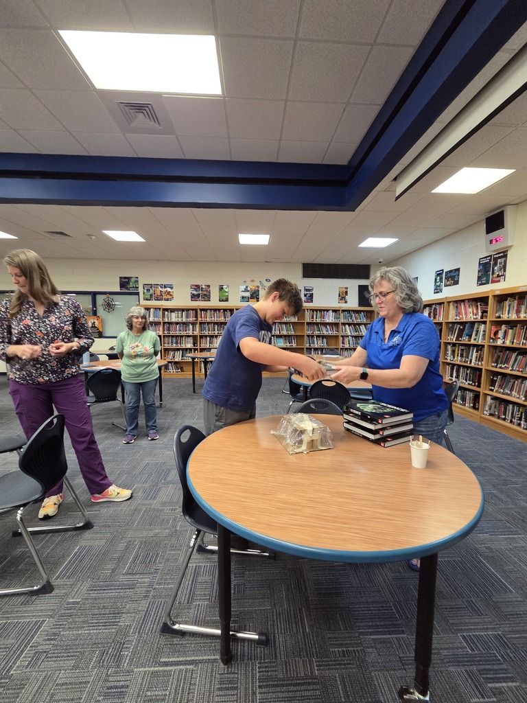 Woman helps student with design in library 