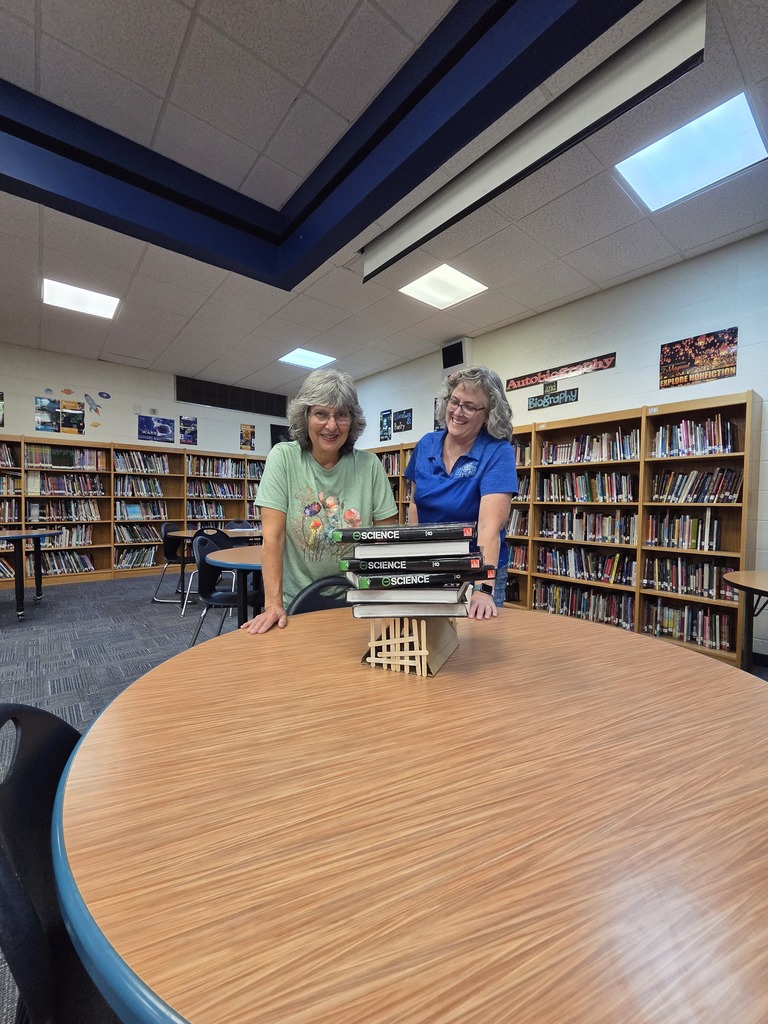 two staff members at a table with their scultpure