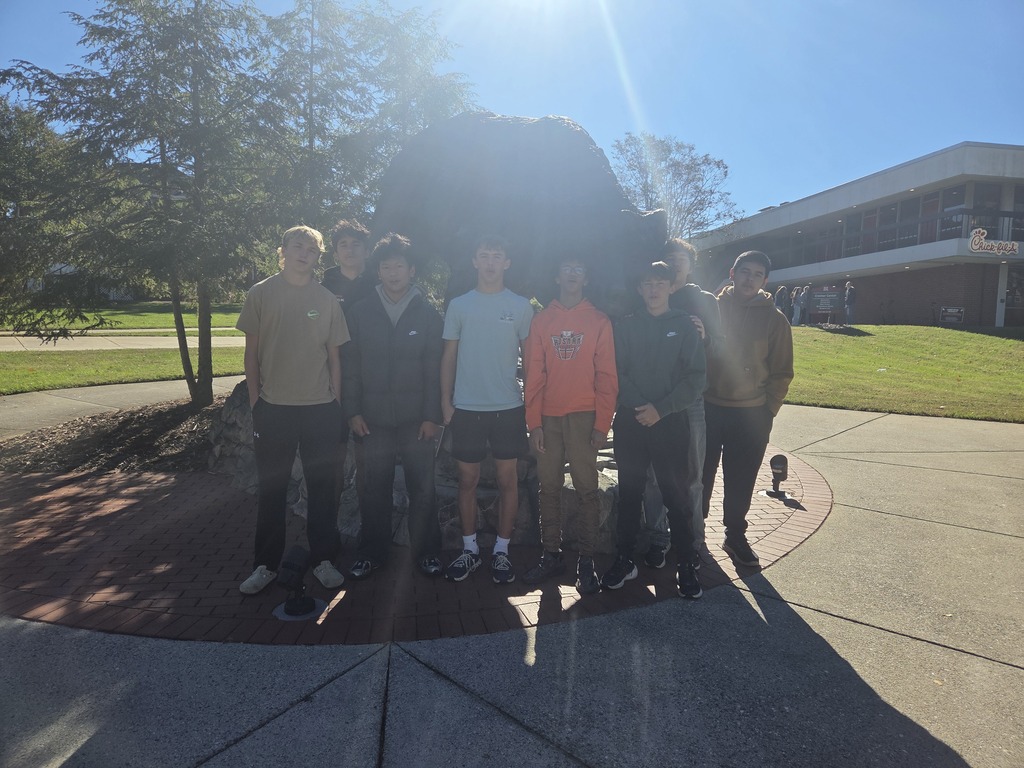 students pose in front of rock