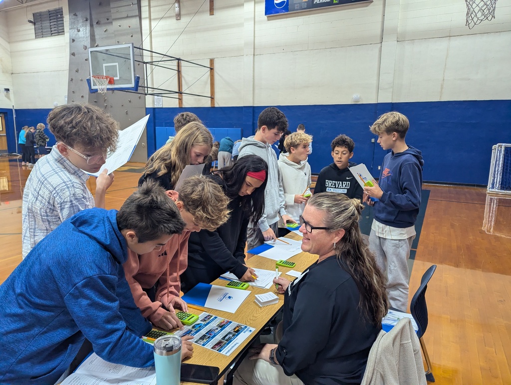Students around a table looking at documents