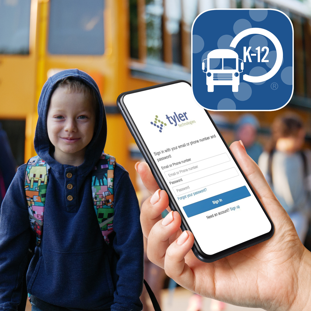 A smiling young boy wearing a backpack stands in front of a school bus, while a hand in the foreground holds a phone displaying the MyRide K-12 app login screen. The app's logo is in the top right corner.