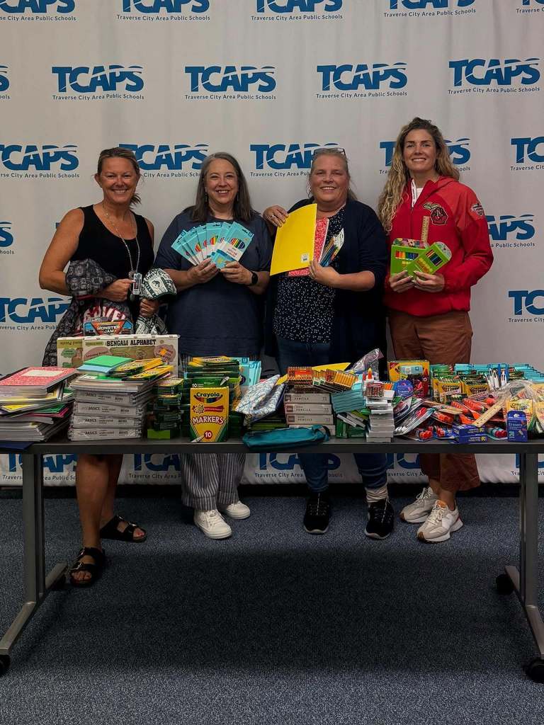 TCAPS staff with community partners holding school supplies
