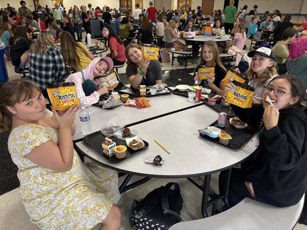 students at the cafeteria table eating tacos
