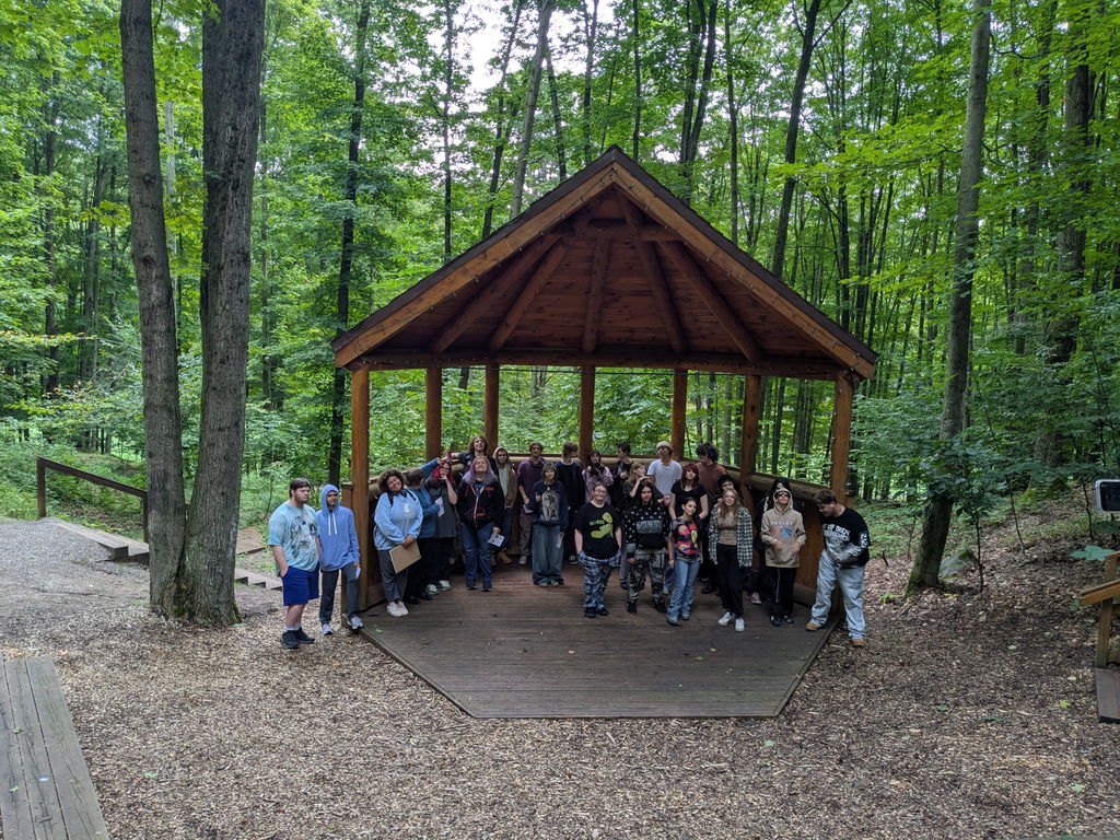 A group of students gather under a gazebo at the Michigan Legacy Art Park.