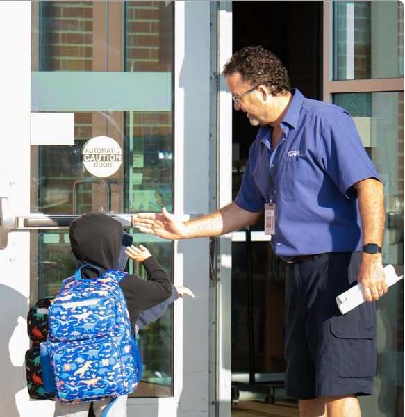 People outside a door high fiving 