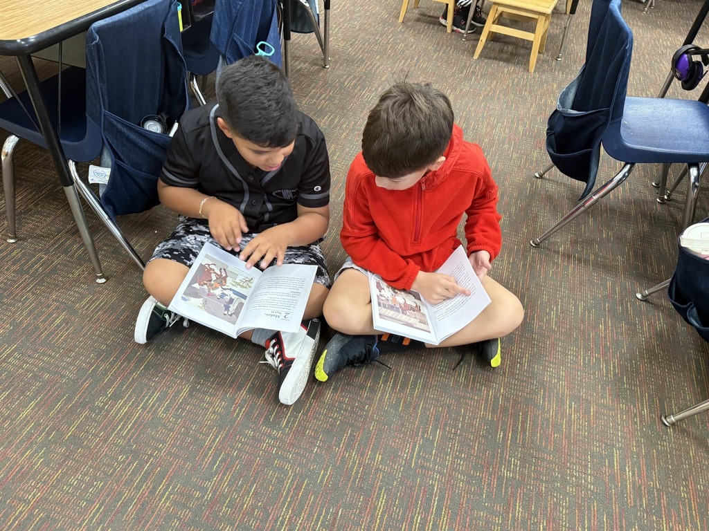 two students sitting on the carpet