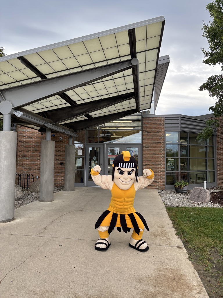 Trojy showing muscles in front of school