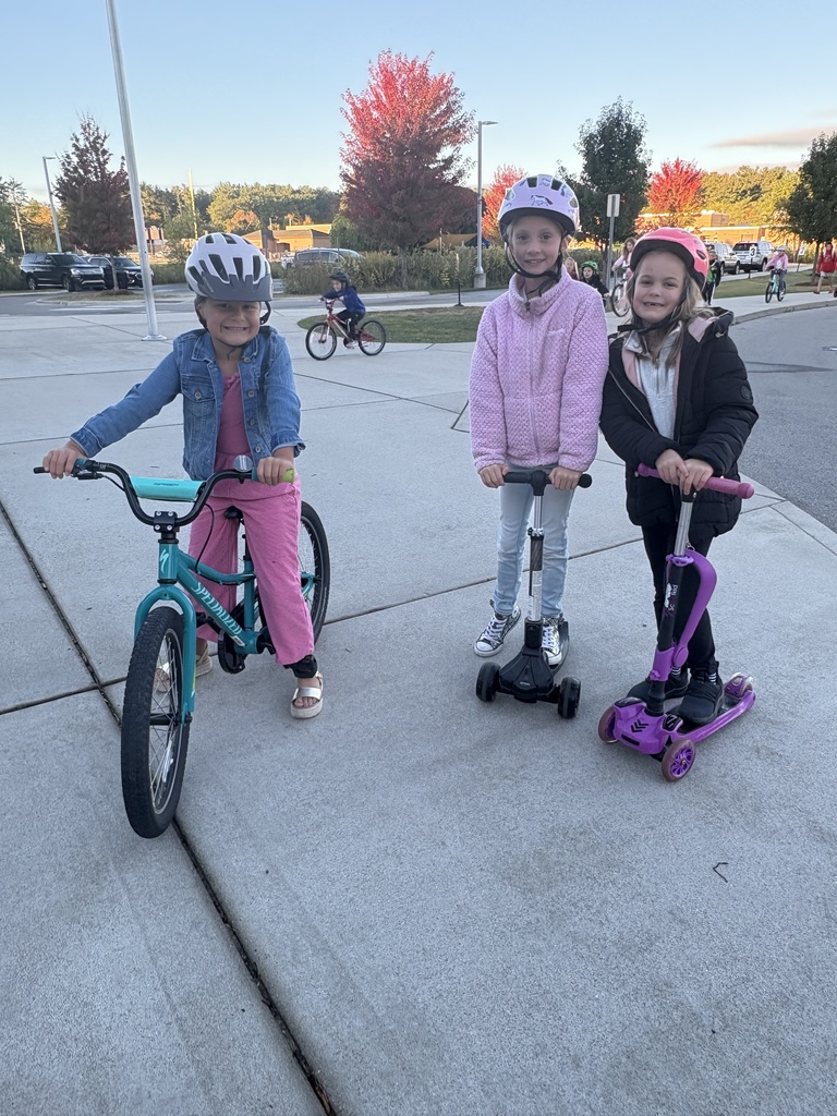 Three students - one on a bike and two on scooters