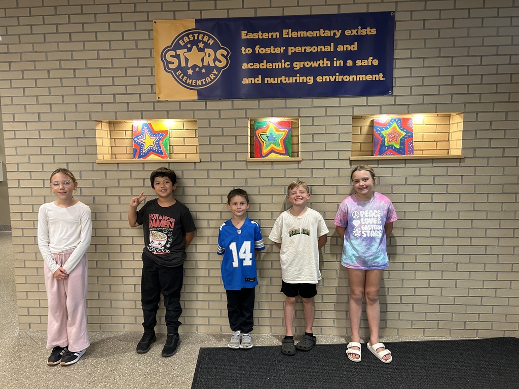 Star students standing against the school wall