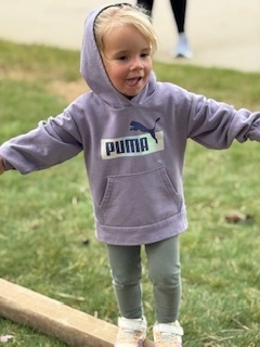 Move- A -Thon. A child with her arms open and a smile on her face.