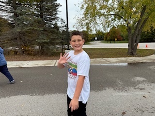 Move- A -Thon. A child waving at the camera.