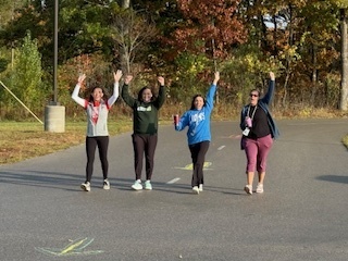 Kindergarten teachers leading the way! Walking in the move a thon with their hands in the air.