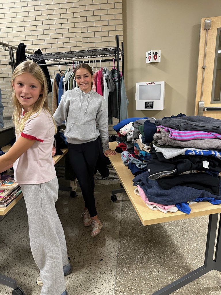 Two students standing in the lost and found area of the school
