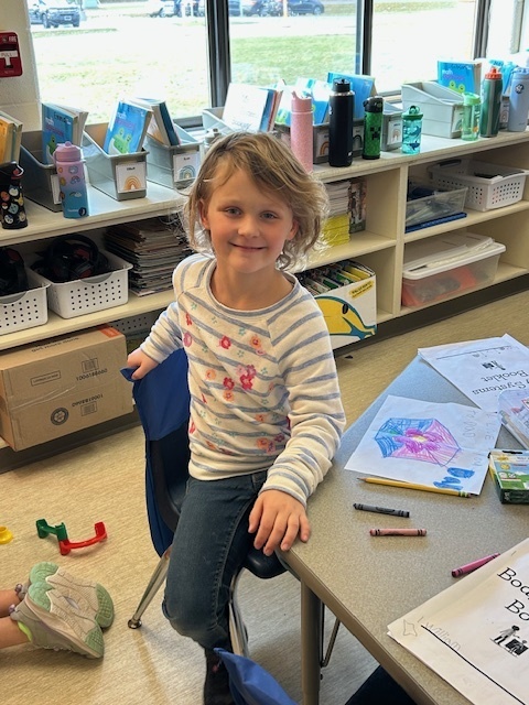 student sitting at a desk coloring a picture
