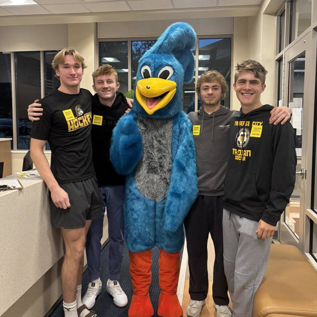 students standing with mascot in hallway