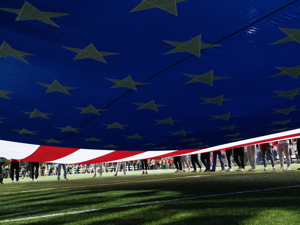 Students holding giant American flag on the field prior to kickoff