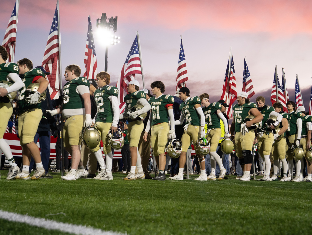 TC West players shaking the hands of several Veterans, first responders, active-duty military, and area heroes before kickoff on football field
