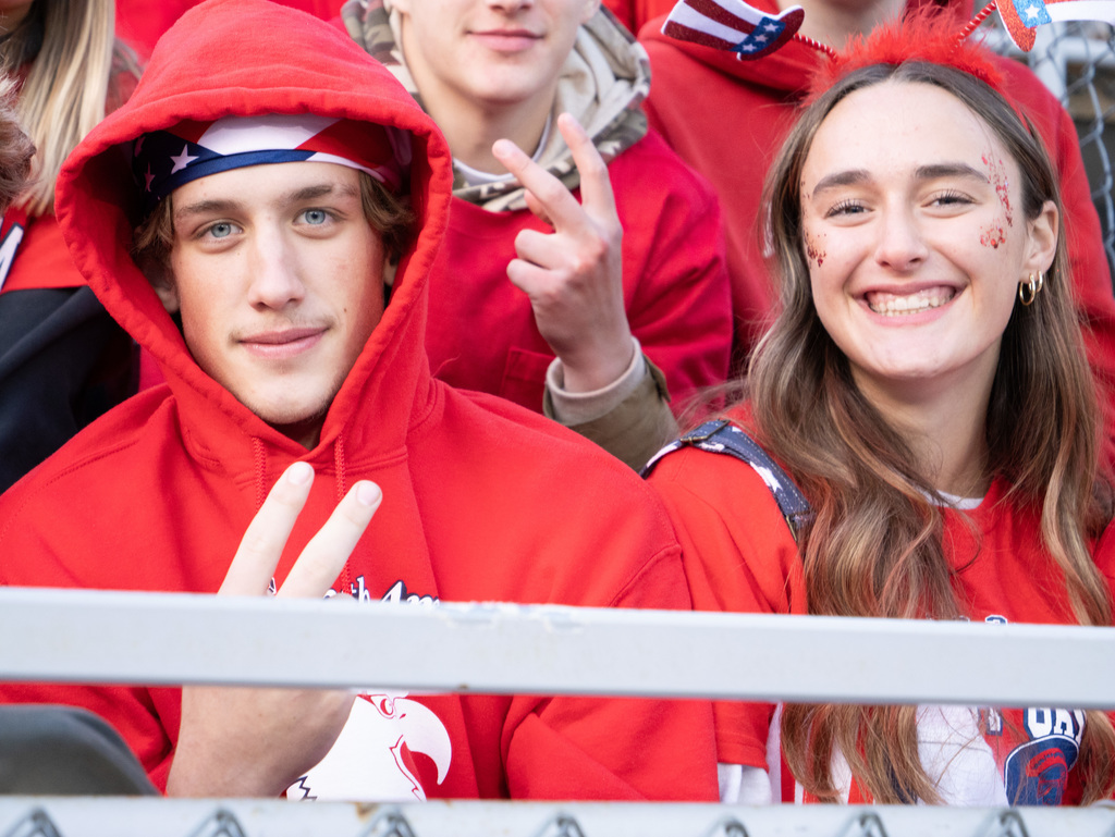 Students smiling in the football stands