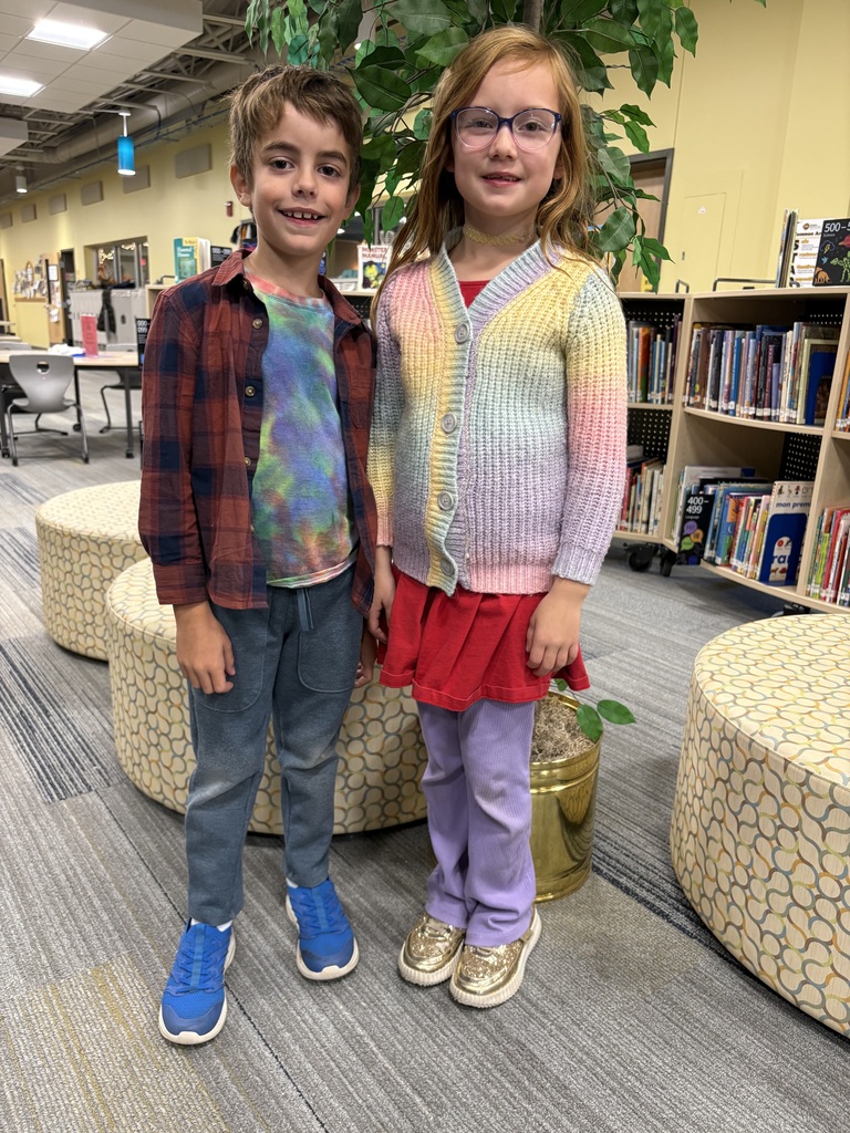 Two first grade students side by side in library