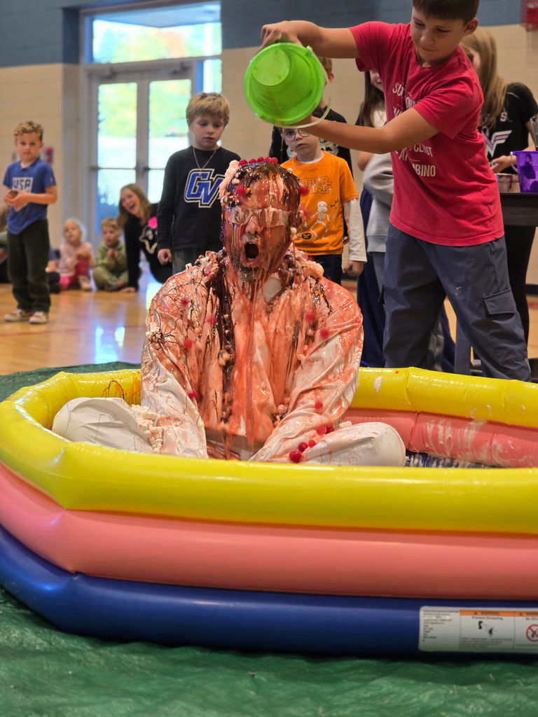Students pouring syrup on principal