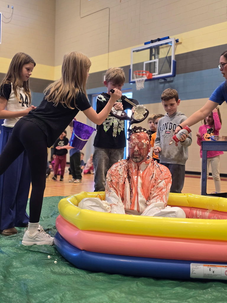 Students pouring ice cream on principal