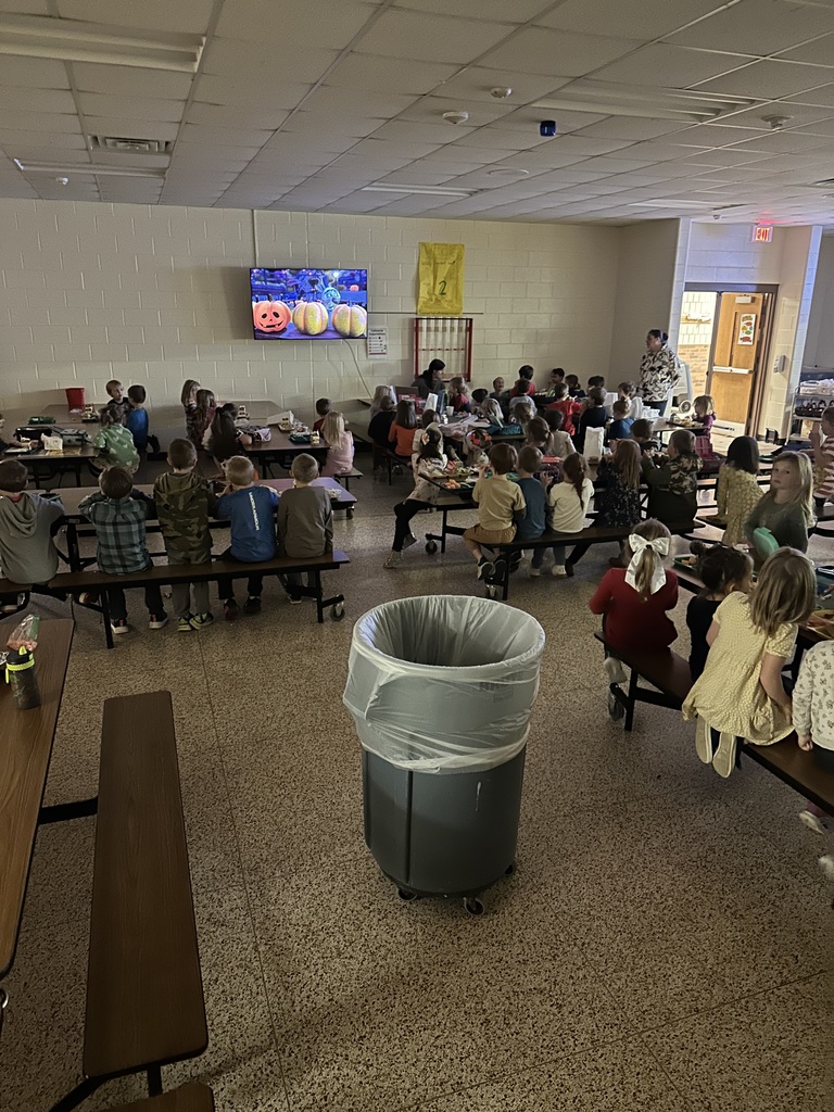 Student in the cafeteria watching a  Halloween movie on the tv.