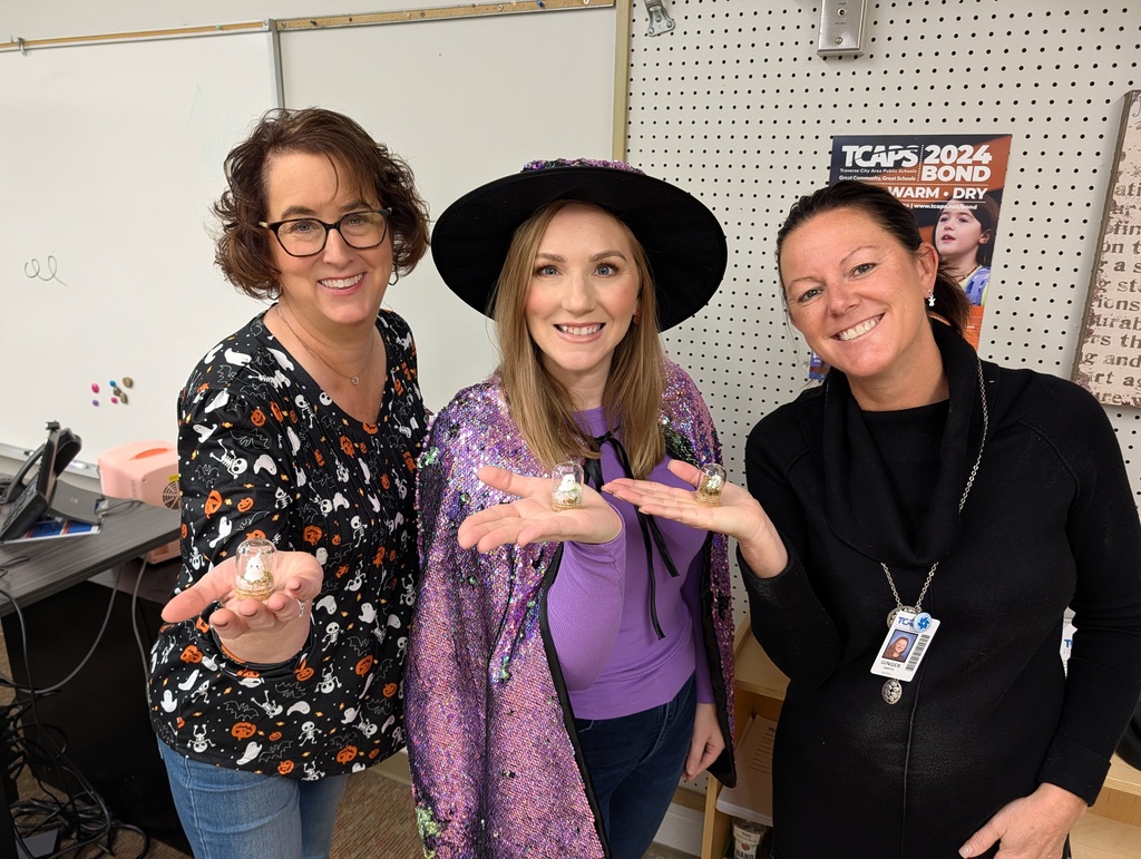 Three women in Halloween attire smiling.
