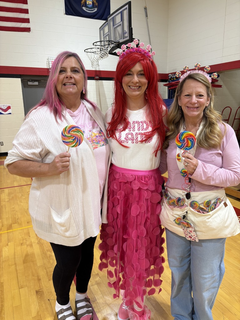 Staff dressed in pink holding lollipops