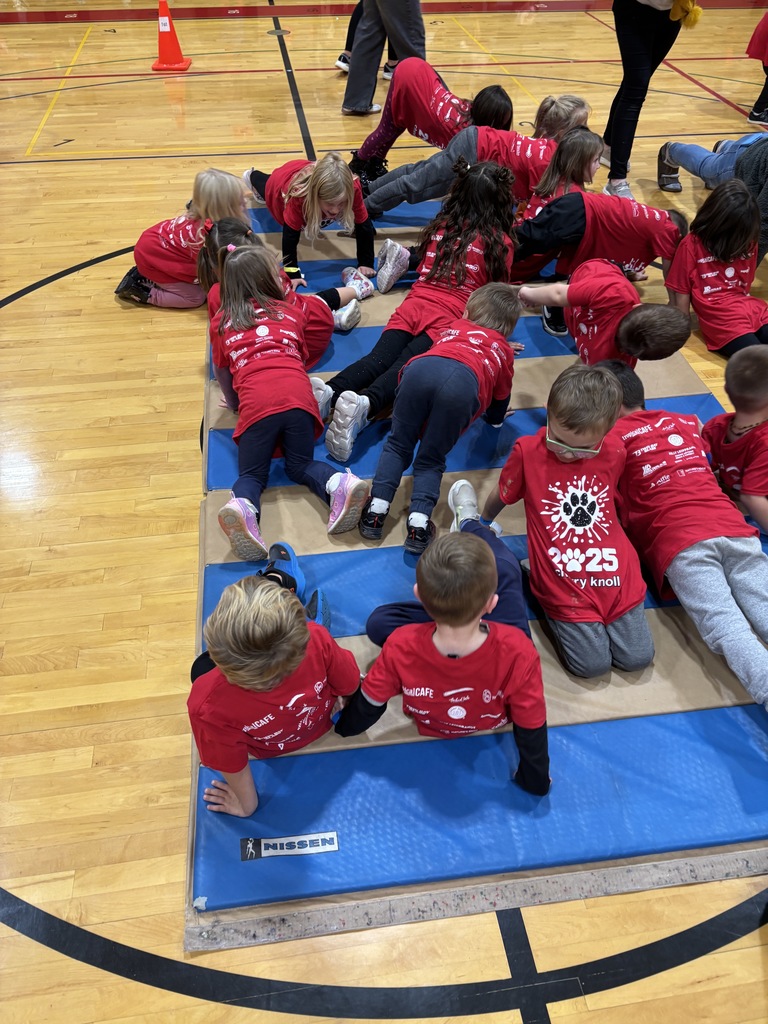 Kindergarten students on mat doing sit ups and push ups