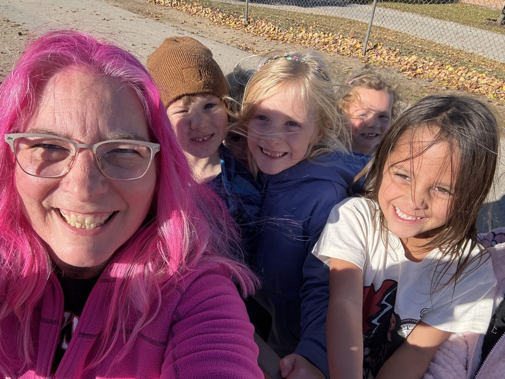pink haired principal with students on the playground