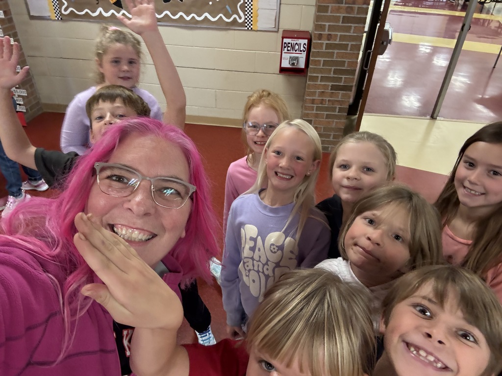 Pink haired principal with students in the hallway