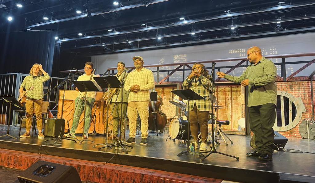 People standing on stage with musical instruments