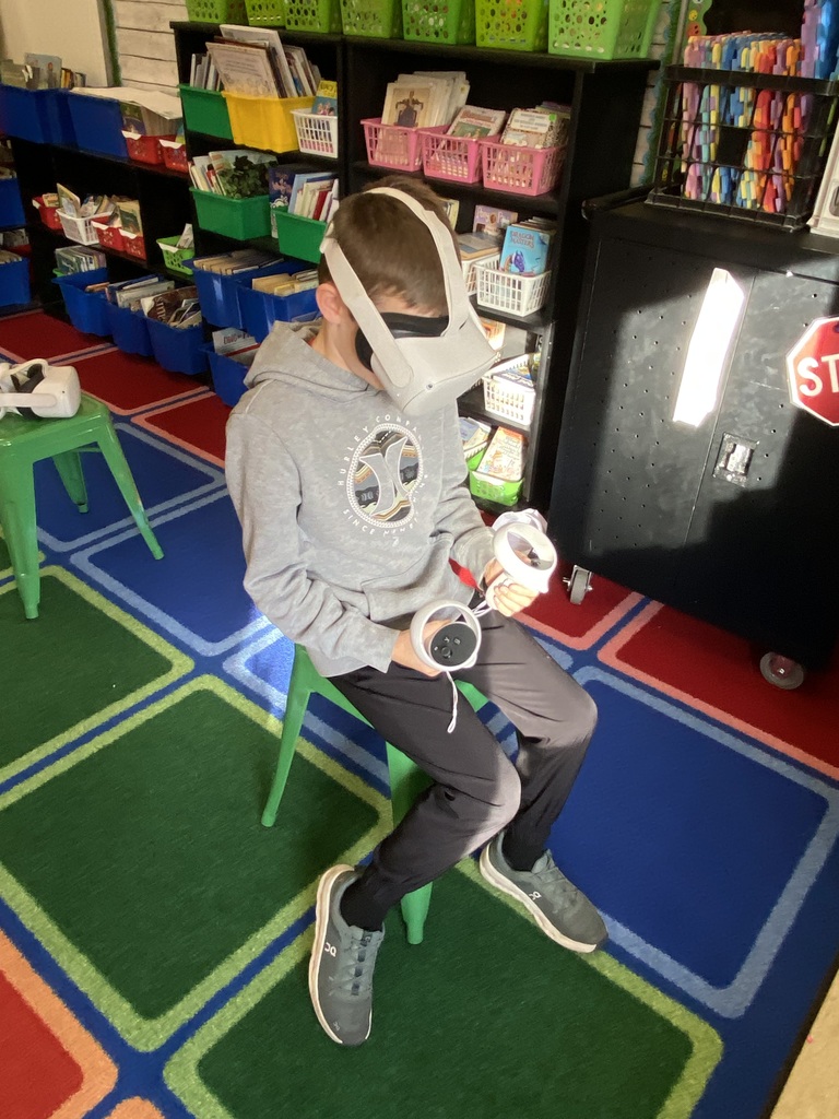 Student sitting on a green stool using a VR headset