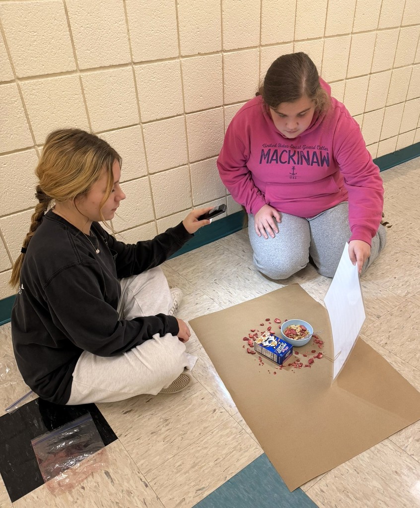 two students working on lighting and shadows for pictures