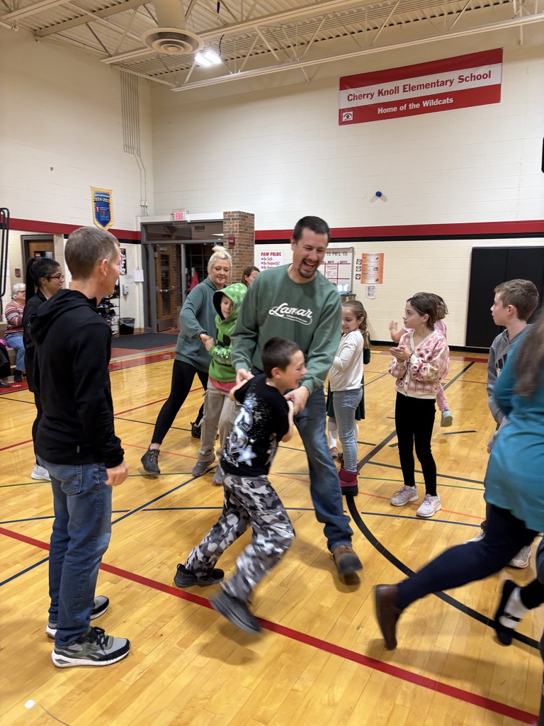 A father and his son holding hands as they dance through people on both sides