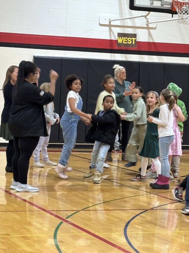 Two students holding hands as they dance through people on both sides