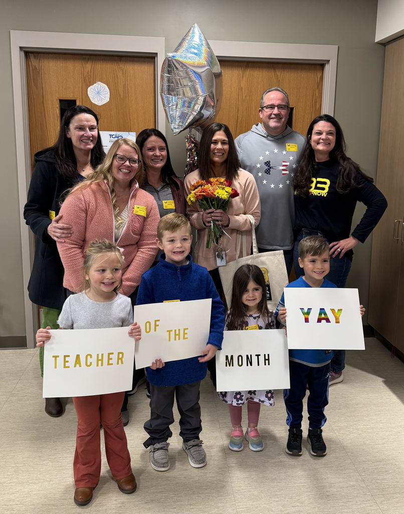 students holdding signs with staff members standing behind them